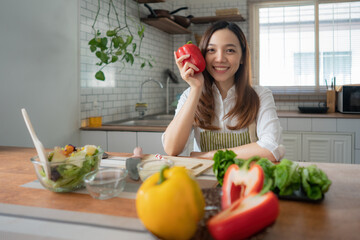 Asian woman preparing salad in the kitchen at home