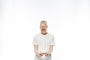 happy albino man in t-shirt using smartphone on white background