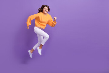 Fototapeta na wymiar Full length profile photo of excited active person jump hurry run empty space isolated on violet color background