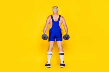 Full body size photo of old age senior hold dumbbels showing big back stay behind professional sportsman isolated on bright yellow color background