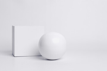 Square podium and sphere in white color for product presentation.