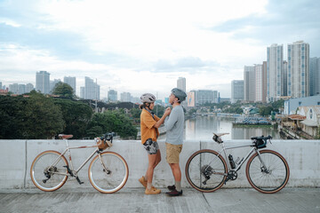 A young cycling couple by the bridge