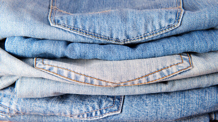 jeans of different shades of indigo color in a pile