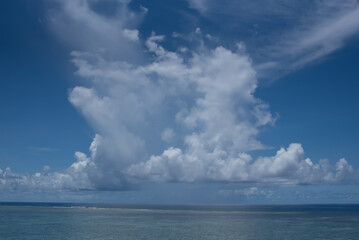 Naklejka na ściany i meble White cumulus clouds in blue sky over sea landscape, big cloud above ocean water panorama, horizont