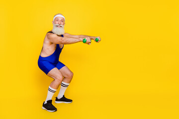 Fototapeta na wymiar Photo of funky positive retired guy wear blue overall pumping arms sit ups empty space isolated yellow color background