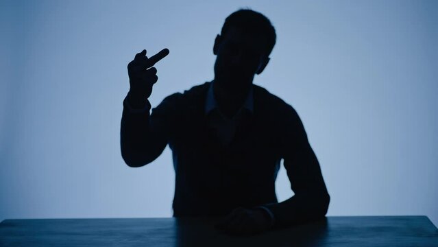 Silhouette of a rude angry man demonstrating middle finger. Humiliating and disrespectful hand sign