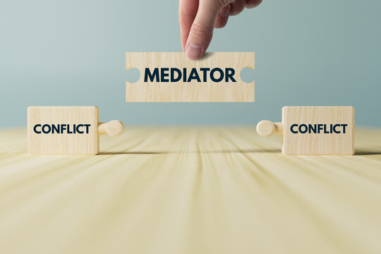 Wooden blocks, puzzles with the word conflict and a mediator that connects them. The concept of mediation, helping to resolve disputes, conflicts.