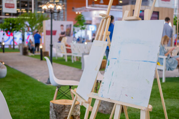 Artistic equipment - artist canvas with unfinished painting at exhibition - selective focus