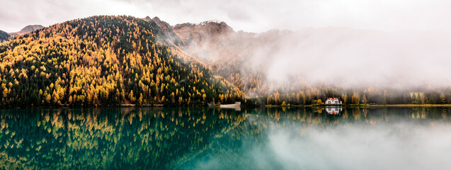 Fog on Lake Anterselva. Horizontal banner that resumes the view of the lake in the morning with the...