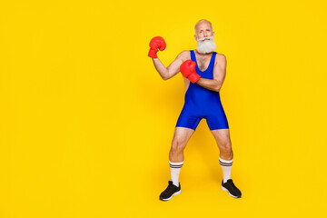 Fototapeta na wymiar Side profile photo of old aged pensioner wear red boxing gloves opponent versus another opponent empty space isolated on yellow color background