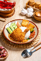 Ayam Goreng Padang. Traditional fried chicken with spice crumbs from Minangkabau, West Sumatra. served on white plate 