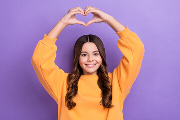 Obraz na płótnie Canvas Portrait of cheerful friendly girl toothy smile arms demonstrate heart gesture isolated on purple color background