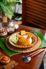 Ayam Goreng Padang. Traditional fried chicken with spice crumbs from Minangkabau, West Sumatra. served on white plate 