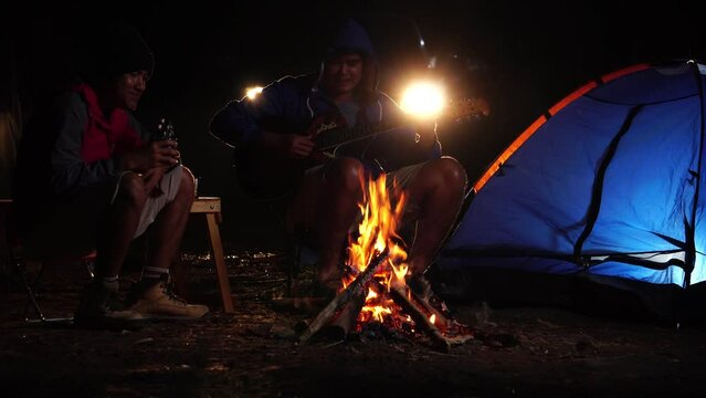 Two male tourists are resting by camping in the wild nature