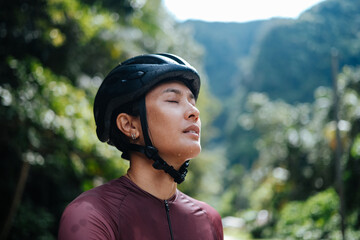 A young female cyclist is practising a breathing exercise.
