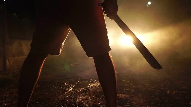 Hand man killer holding weapon in scary night