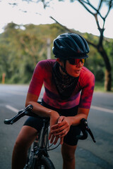 A young female cyclist resting on her bike
