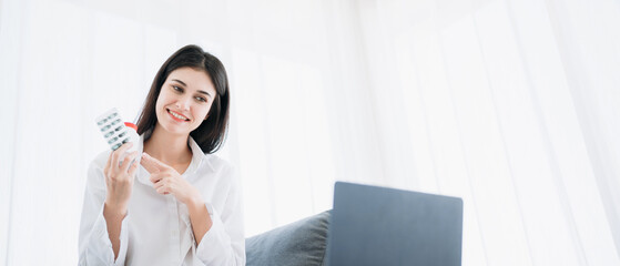 Woman engages in a videoconference with a doctor through her smartphone while at home in isolation...