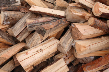 Natural wooden background - closeup of chopped firewood. Firewood prepared for winter Pile of wood logs. Chopped wood for fireplace heating, alternative to gas and electricity.