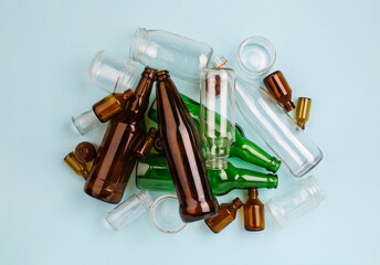 Separate collection of glass garbage. Colorful bottles and cans for recycle. Eco friendly concept. Recyclable glass waste on blue: empty glass jars and bottles. Zero waste. Save the planet. Go green
