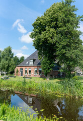 Fototapeta na wymiar Frisian farmhouse in Earnewald in Fryslan (Friesland, The Netherlands) along water.
