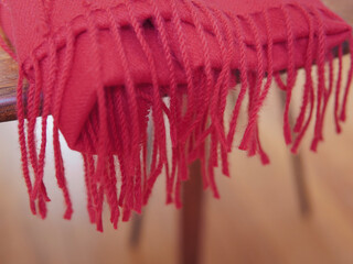 Close up of red autumn and winter scarf made from polyester with fringe