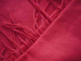 Close up of red autumn and winter scarf made from polyester with fringe