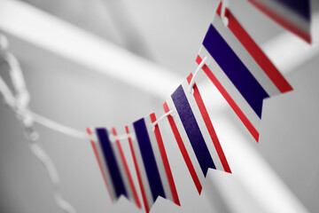 A garland of Thailand national flags on an abstract blurred background
