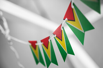 A garland of Guyana national flags on an abstract blurred background