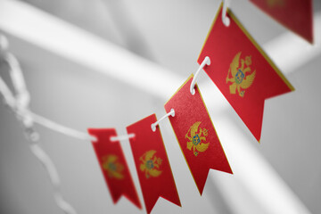 A garland of Montenegro national flags on an abstract blurred background