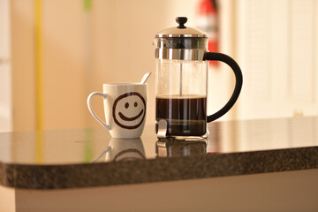 French press coffee maker and a cup