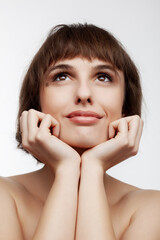 studio portrait of a beautiful brunette girl with short hair looking up isolated on white background.