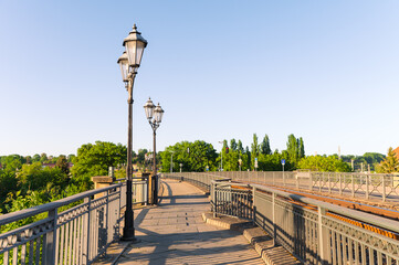 pedestrian walkway with lanterns next to train railway in the afternoon in city Pirna in Germany