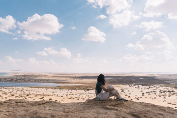 Girl on top of a hill in the Faiyum desert, contemplating the oasis.