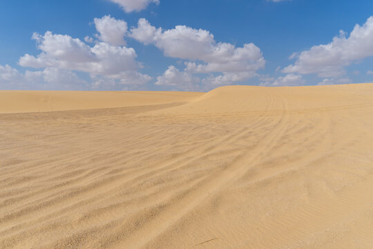Image of the Sahara desert in Egypt, with yellow sand, and dunes, on a sunny day with clouds © Montse