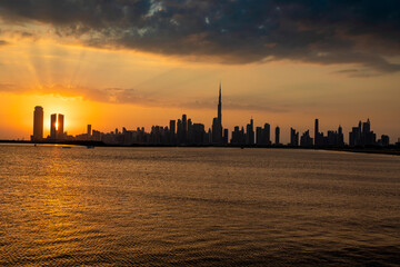 Dubai skyline during sunset. Dubai Downtown skyline panorama with reflections in Dubai Creek, gold colors, seen from Al Jaddaf walk Dubai.