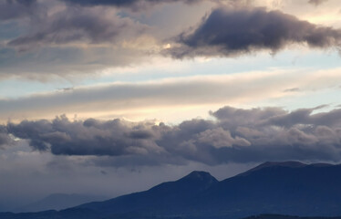 Nuvole nere e cielo azzurro sopra le montagne