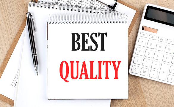 BEST QUALITY is written in white notepad near a calculator, clipboard and pen. Business concept