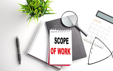 SCOPE OF WORK text on white paper. the inscription on the notebook