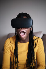 Shocked black woman with vitiligo skin in VR goggles