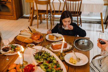 Cute girl drinking milk during traditional Christmas dinner