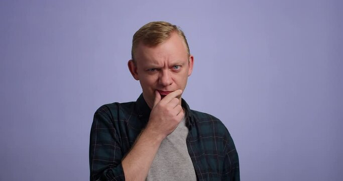 Young man looking at camera, giving assessing look. studio shot