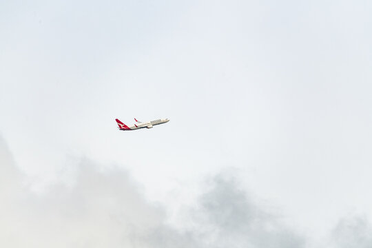 Coolangatta Airport, New South Wales, Australia - April 24th 2022: Qantas Commercial Airline flying through the air with cloudy background. 