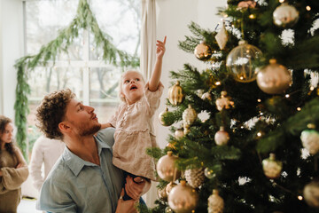 Father and his little daughter decorating Christmas tree