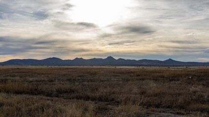 rural landscape mountains on horizon sunset weeds in foreground