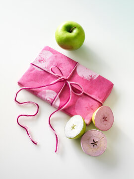 Gift, Craft demonstration of how to use granny smith apples cut in half and dipped in pink and white paint to make wrapping paper