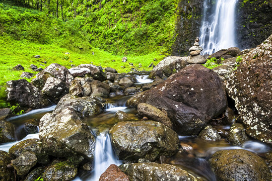 Hanakoa Falls cascading down through lush green cliff, Na Pali Coast State Park; Kauai, Hawaii, United States of America