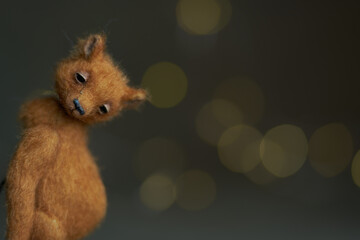 Cute teddy bear isolated on light background. Holiday glowing backdrop. Defocused background with...