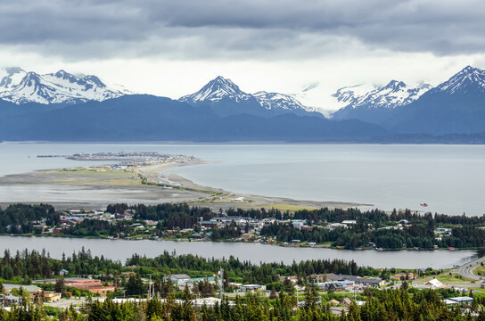 Aerial view of the city of Homer and the Homer Spit in Kenai Peninsula Borough, in Kachemak Bay with the Kenai Mountain Range in the distance; Kenai Peninsula, Alaska, United States of America