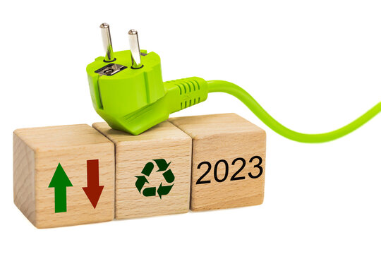 energy prices in 2023, energy and environmental concept, wooden blocks with date, increase and decrease indicators, green cable with plug, renewable energy symbol, white background - Powered by Adobe